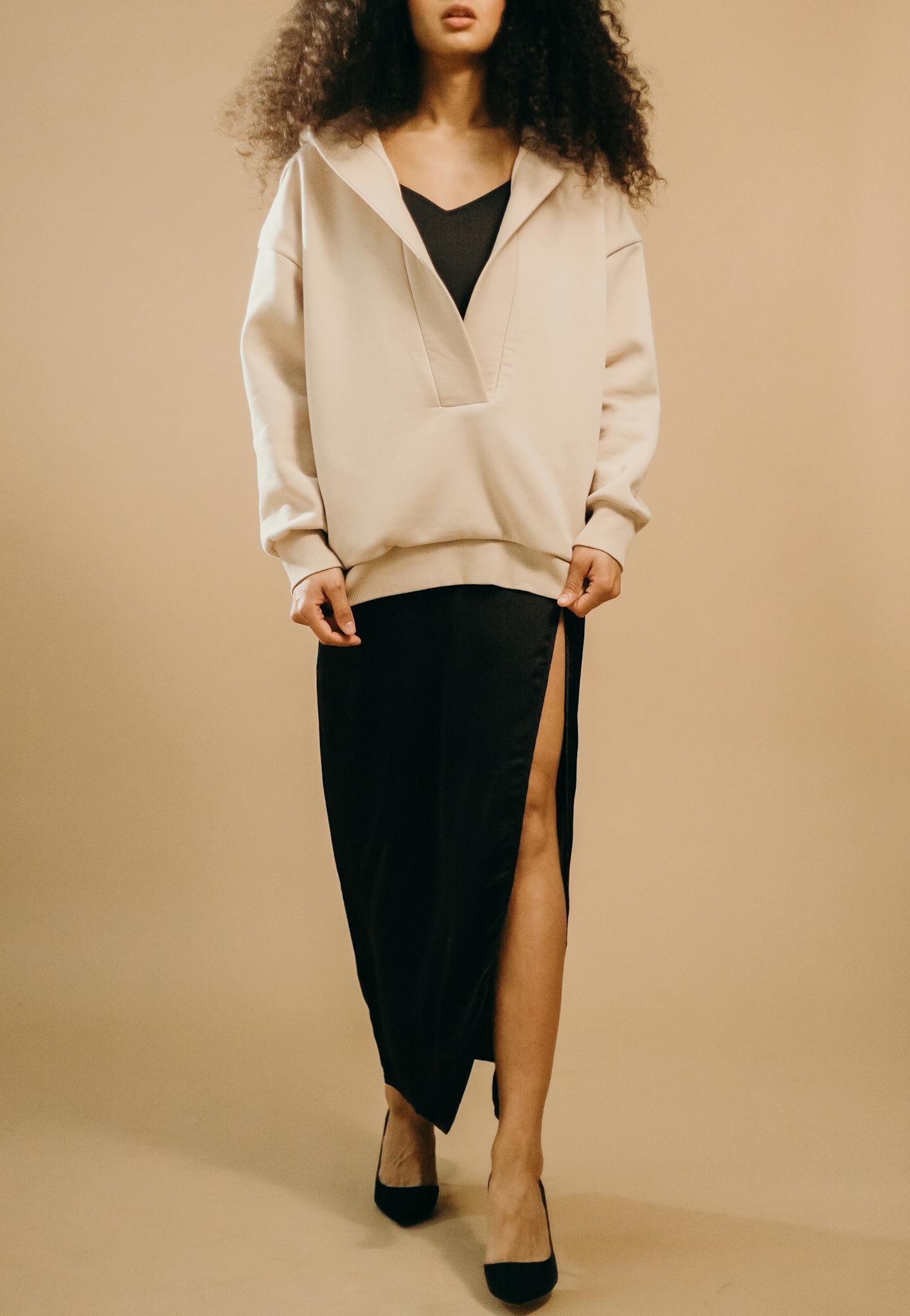 Stylish woman with afro hair in a modern outfit, full-length portrait.
